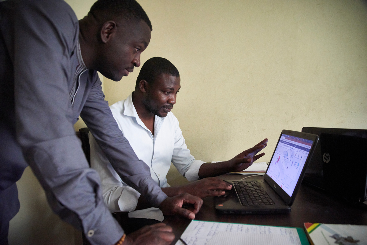 Dos hombres trabajan en una computadora portátil