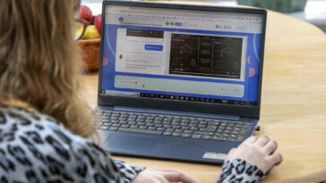 Una niña sentada en un escritorio con una computadora portátil interactuando con un cuestionario de matemáticas en línea