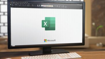 Microsoft Office Excel en la pantalla de la computadora.  Monitor, teclado y airpods en mesa de madera.  Enfoque selectivo.  Río de Janeiro, RJ, Brasil.  enero 2022