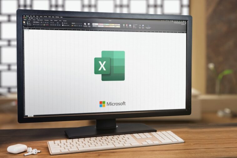 Microsoft Office Excel en la pantalla de la computadora.  Monitor, teclado y airpods en mesa de madera.  Enfoque selectivo.  Río de Janeiro, RJ, Brasil.  enero 2022