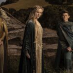 Galadriel, Gil-galad, and Elrond wear regal clothes as they stand in a field for a press photo for The Rings of Power