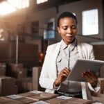 A manager uses a tablet in a warehouse / industrial environment.