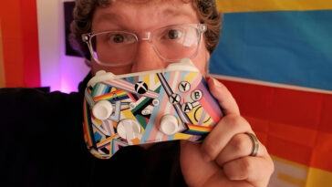 El hombre sostiene el controlador Xbox Pride