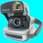Una cámara instantánea Polaroid P600 sobre un fondo azul brillante