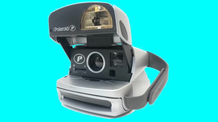 Una cámara instantánea Polaroid P600 sobre un fondo azul brillante
