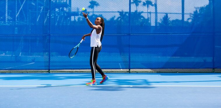 Mujer lanza una pelota de tenis en el aire