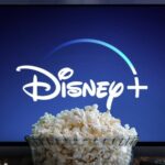 Giant bowl of popcorn in front of TV screen with Disney+ logo displayed