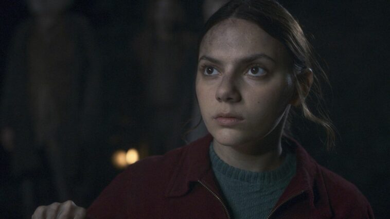 A dirty-faced Lyra looks out of a window in His Dark Materials season 3 on HBO Max