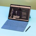 La Surface Pro 9 en modo portátil vista desde arriba con el lápiz óptico al lado.  La pantalla muestra la página de inicio de The Verge.