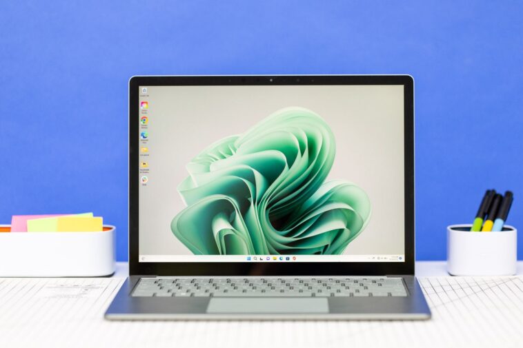 Microsoft Surface Laptop 5 abierta sobre una mesa de oficina.  La pantalla muestra una cinta verde.
