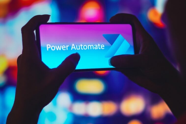 6 de julio de 2022, Brasil.  En esta ilustración fotográfica, la silueta de una mujer sostiene un teléfono inteligente con el logotipo de Microsoft Power Automate en la pantalla.
