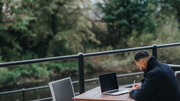 Una persona leyendo y planeando para el nuevo año en una mesa al aire libre.