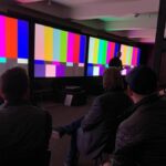 2022 Projector shootout with screens showing color bars test patterns