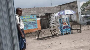 Un niño junto a un puesto callejero que vende tarjetas de telefonía móvil y acceso a Internet en Kinshasa en 2015