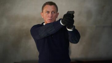 James Bond as played by Daniel Craig holding gun in No Time To Die