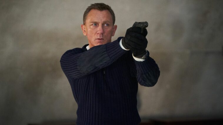 James Bond as played by Daniel Craig holding gun in No Time To Die