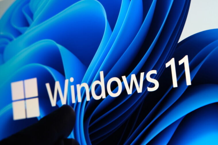 Logotipo de Windows 11 visto en la pantalla de la tableta y el usuario apuntándolo con el dedo.  Stafford, Reino Unido, 1 de julio de 2021