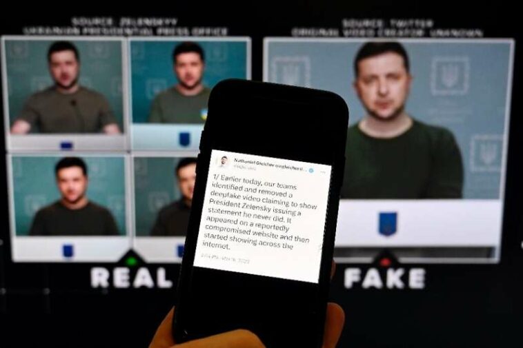 Un teléfono muestra una declaración del jefe de política de seguridad de Meta frente a un video falso del presidente ucraniano Volodymyr Zel