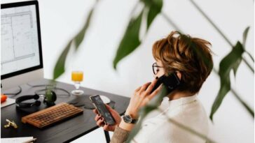 mujer en llamada telefónica en el trabajo