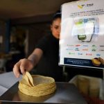 Un cartel en una tienda de la Ciudad de México informa a los clientes sobre una nueva aplicación que pueden usar para comprar tortillas.