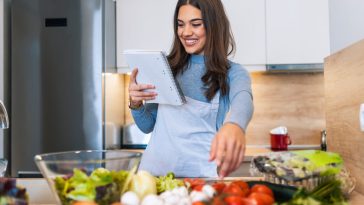 Mamá leyó cuidadosamente una receta mientras prepara una comida.